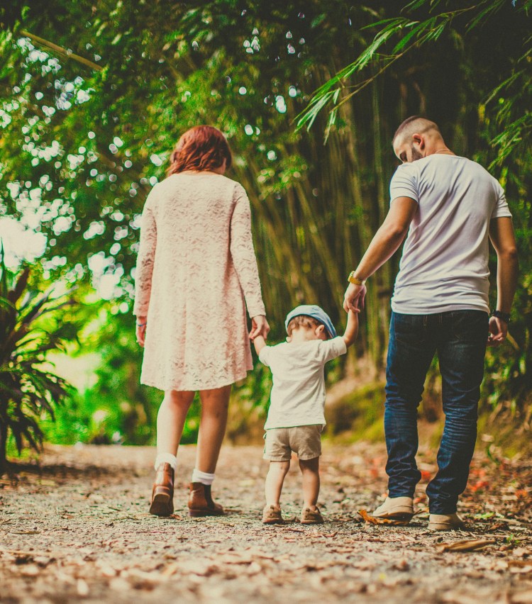 Parents holding small child's hands